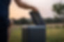 Man upening the lid of a Black Compost Trelino Toilet